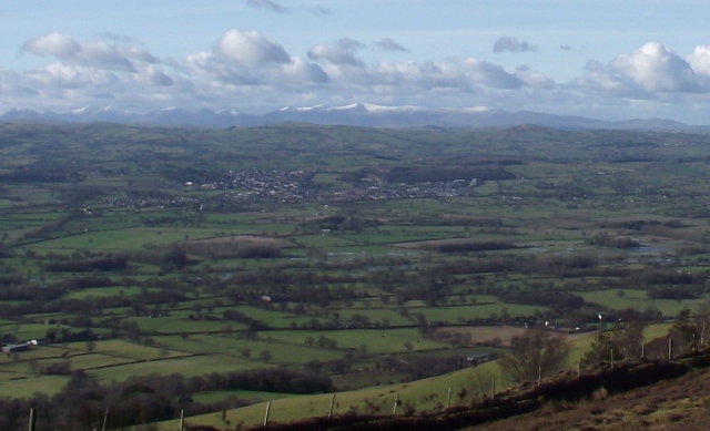 The snow-capped mountains of Snowdonia, with the town of Denbigh in the middle ground